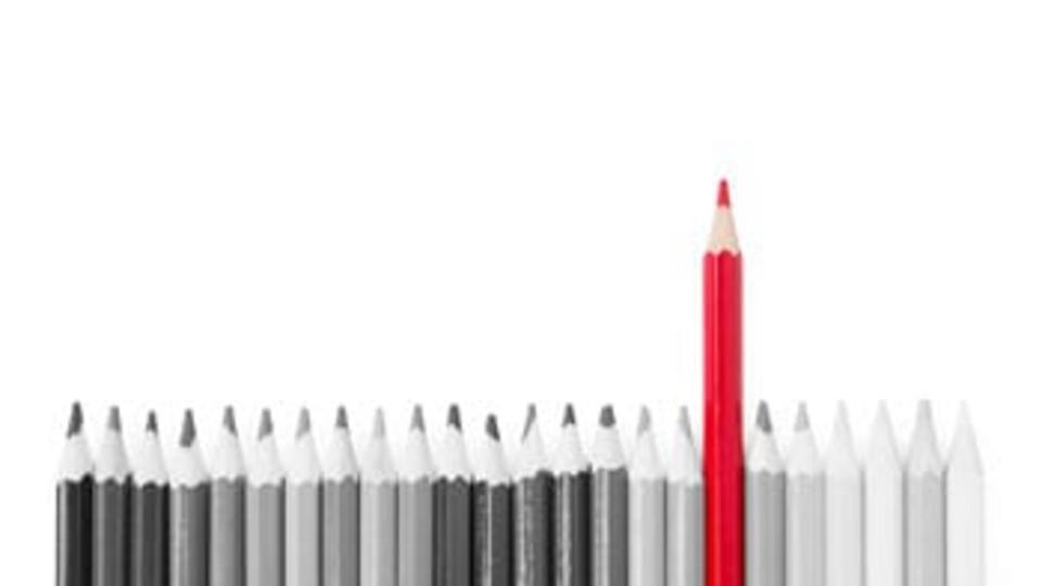 Black and White Photo of Pencils with One Red Pencil 